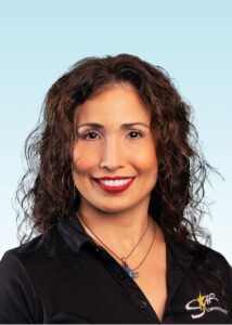 Smiling team member with curly hair wearing a black logo polo shirt
