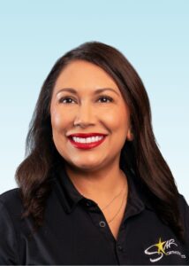 Smiling woman with long dark hair wearing a black team polo shirt