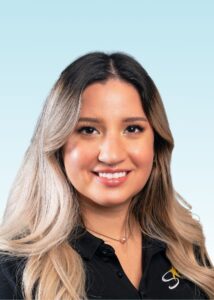 Smiling team member with long ombre hair wearing a black polo shirt
