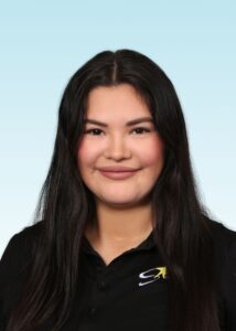 Smiling team member with long dark hair wearing a black polo shirt with embroidered star logo