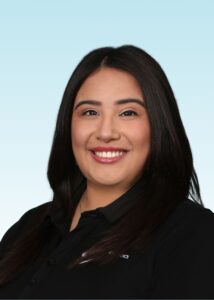Smiling team member with long dark hair wearing a black polo shirt