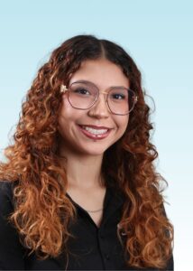Smiling woman with curly hair and glasses wearing a black shirt