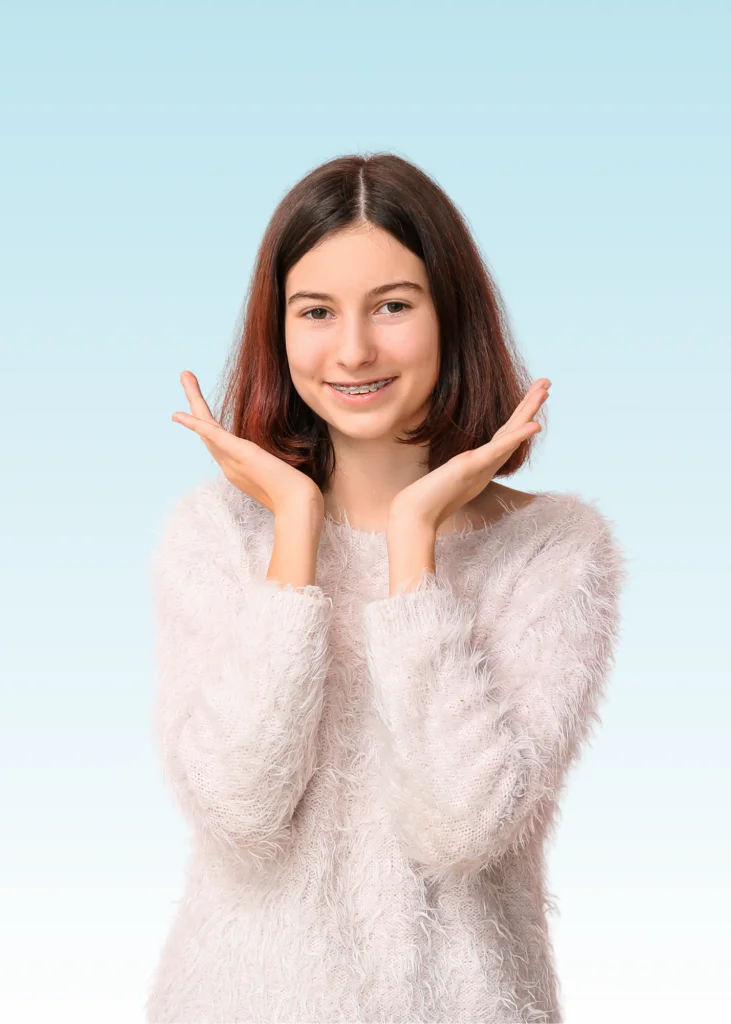 Smiling teen girl with braces framing her face with both hands