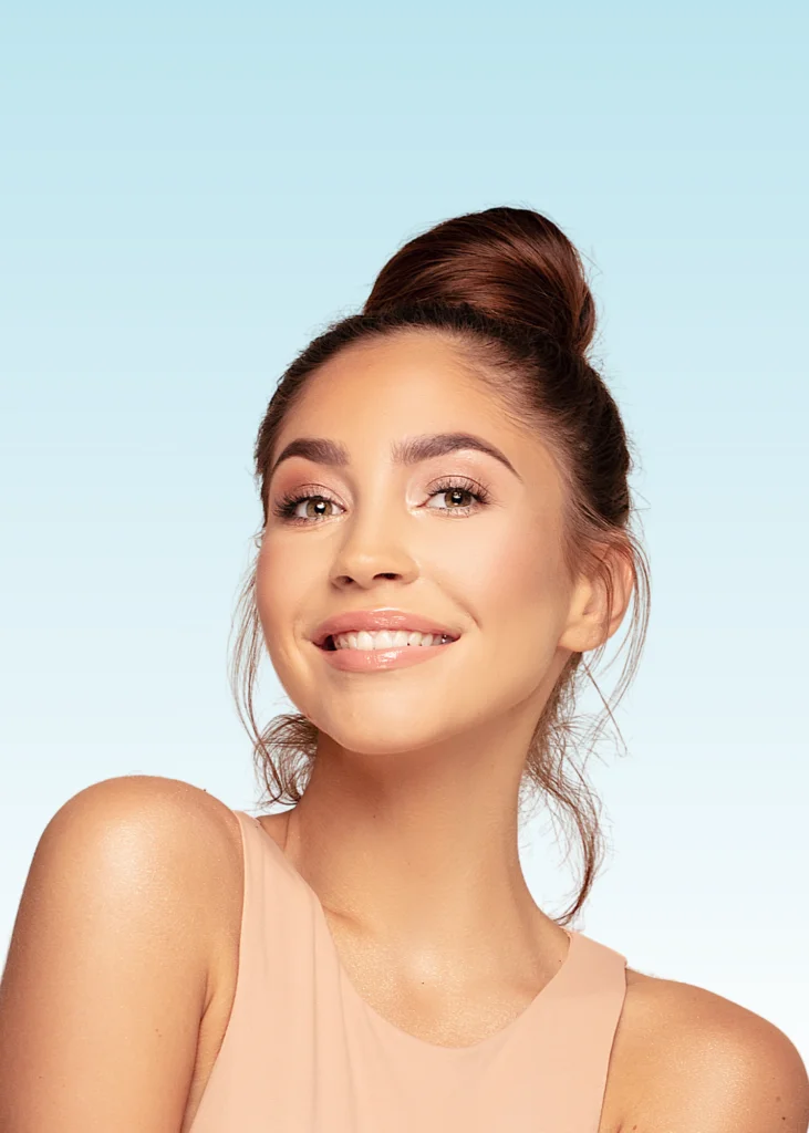 Smiling young woman with hair in a bun showing a bright, straight smile