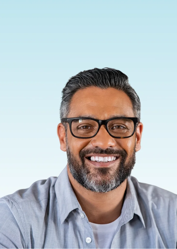 Smiling man with glasses and a graying beard showing straight white teeth