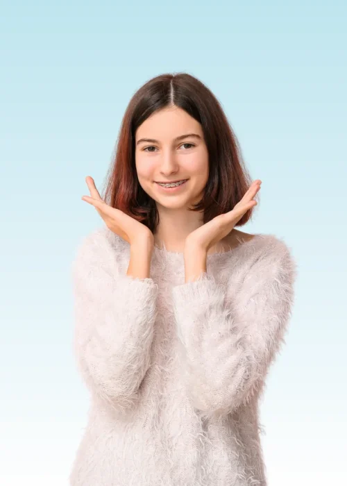 Smiling teen girl with braces framing her face with both hands