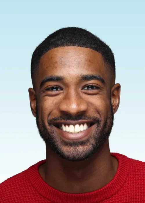 Smiling man with beard wearing a red sweater showing straight white teeth